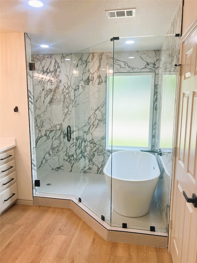 113 County Road 3198, Decatur, TX 76234 - full bath with wood finished floors, a marble finish shower, a freestanding bath, and vanity