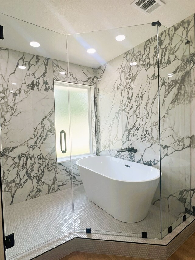 113 County Road 3198, Decatur, TX 76234 - bathroom with a marble finish shower, tile walls, a freestanding tub, and recessed lighting