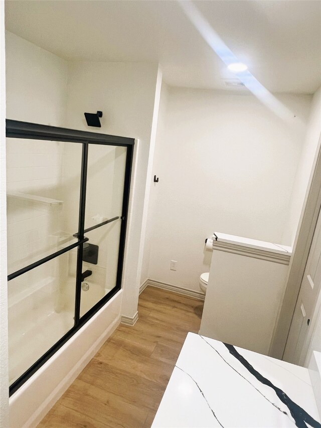 113 County Road 3198, Decatur, TX 76234 - bathroom featuring wood finished floors, baseboards, toilet, and shower / bath combination with glass door