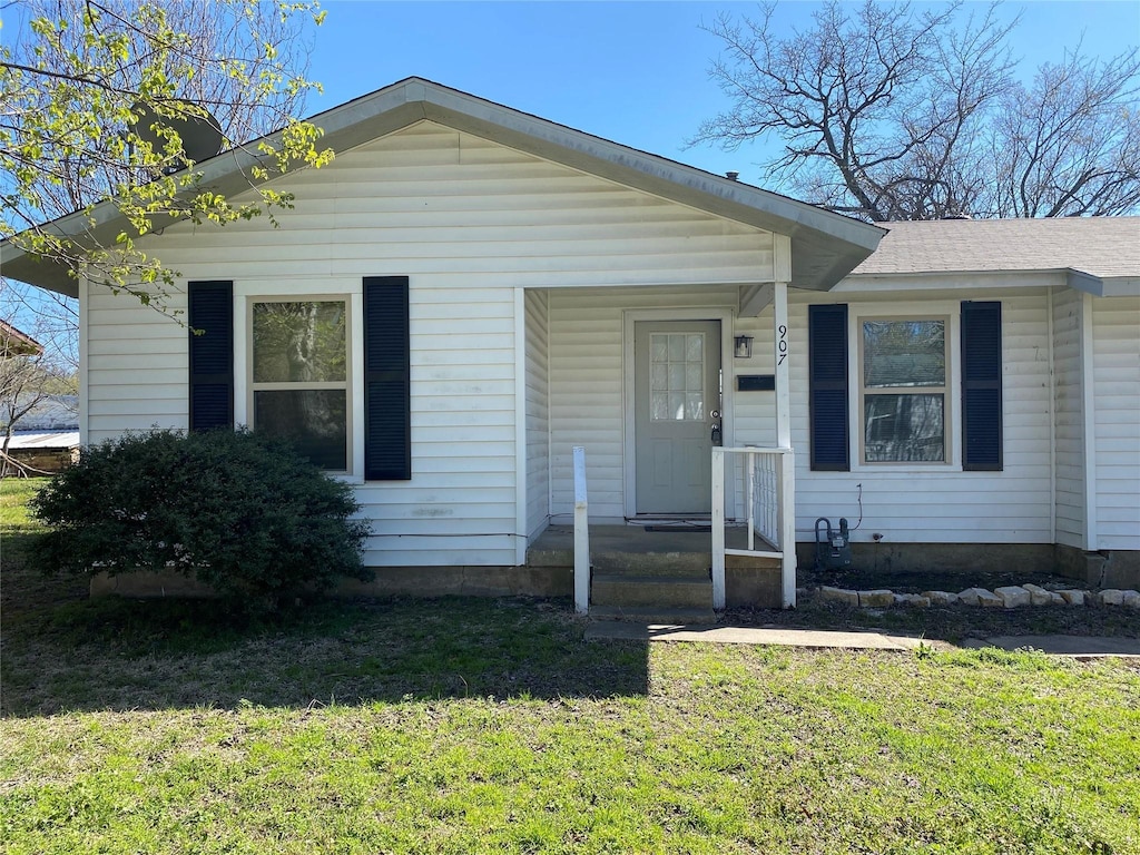 907 W 8th St, Bonham, TX 75418 - bungalow-style home with a front yard and a shingled roof