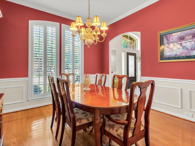 1457 Susan Ln, Carrollton, TX 75007 - dining room with healthy amount of natural light, a chandelier, wainscoting, ornamental molding, and light wood-style flooring
