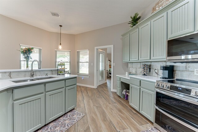 6367 Bridle Trl, Caddo Mills, TX 75135 - kitchen featuring stainless steel appliances, a sink, decorative backsplash, and hanging light fixtures