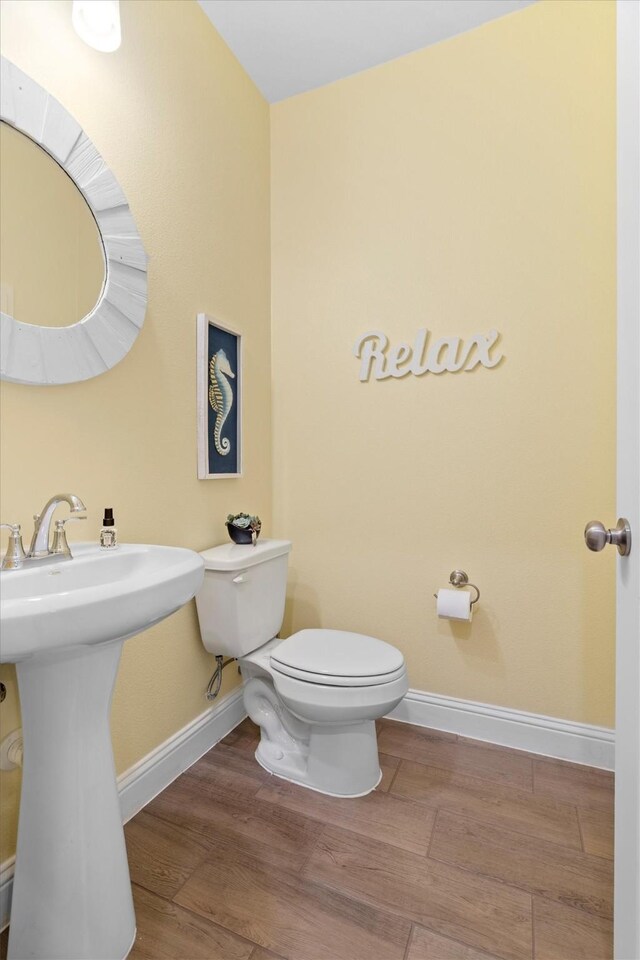 2606 High Cotton Ln, Garland, TX 75042 - bathroom with baseboards, toilet, wood finished floors, and a sink