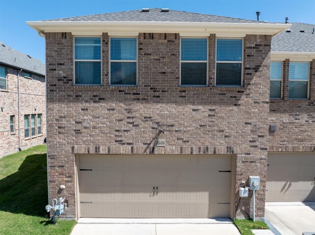 2606 High Cotton Ln, Garland, TX 75042 - view of front of home featuring a garage, brick siding, driveway, and a shingled roof