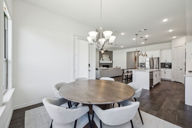 2812 Quill Ln, Northlake, TX 76247 - dining area featuring a chandelier, recessed lighting, dark wood-style floors, a fireplace, and baseboards