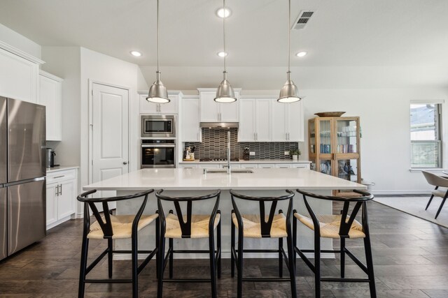 2812 Quill Ln, Northlake, TX 76247 - kitchen featuring appliances with stainless steel finishes, light countertops, recessed lighting, tasteful backsplash, and a kitchen breakfast bar