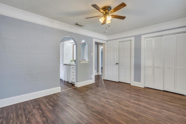 4109 Twin Falls St, Irving, TX 75062 - unfurnished bedroom featuring dark wood-style floors, multiple closets, ornamental molding, and a ceiling fan