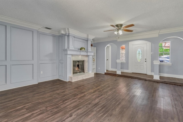 4109 Twin Falls St, Irving, TX 75062 - unfurnished living room featuring a ceiling fan, dark wood finished floors, arched walkways, ornamental molding, and a fireplace