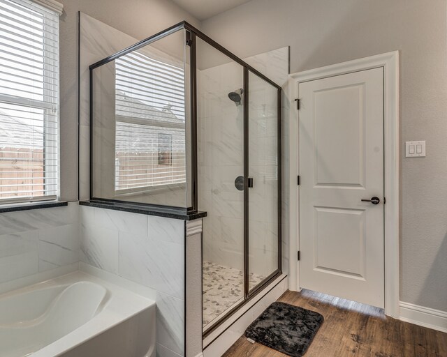 513 Dillon St, Waxahachie, TX 75165 - full bathroom with a bath, a stall shower, and wood finished floors