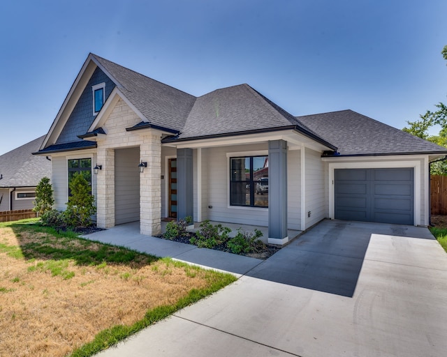 513 Dillon St, Waxahachie, TX 75165 - view of front facade with a shingled roof, concrete driveway, an attached garage, stone siding, and fence