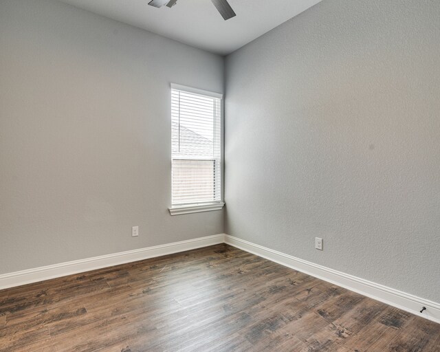 513 Dillon St, Waxahachie, TX 75165 - empty room with dark wood-style floors, ceiling fan, and baseboards