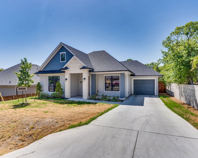 513 Dillon St, Waxahachie, TX 75165 - view of front of home featuring an attached garage, driveway, a shingled roof, and stone siding