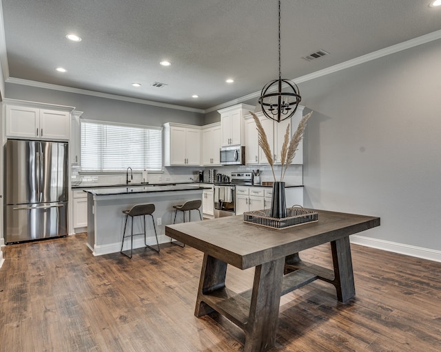 513 Dillon St, Waxahachie, TX 75165 - kitchen featuring stainless steel appliances, dark countertops, white cabinets, crown molding, and recessed lighting