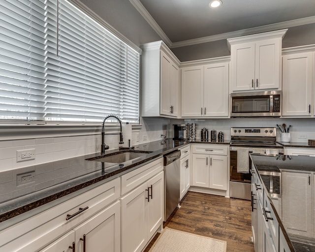 513 Dillon St, Waxahachie, TX 75165 - kitchen with stainless steel appliances, a sink, white cabinets, recessed lighting, and crown molding