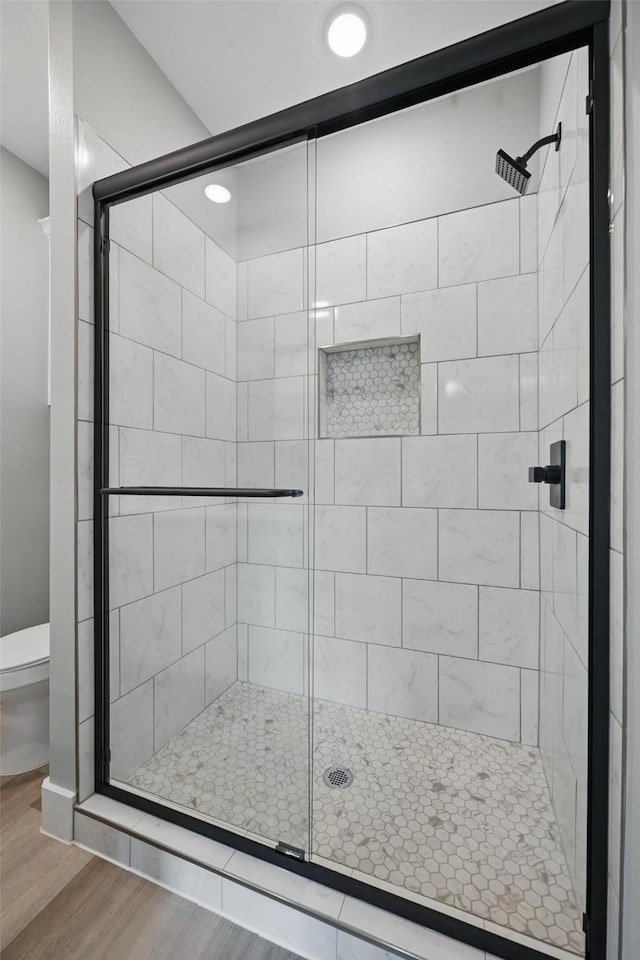2734 W Washington St, Denison, TX 75020 - bathroom with wood finished floors, a shower stall, and toilet