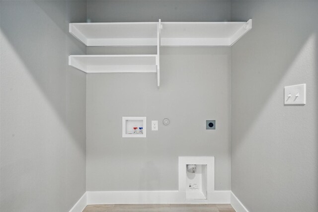 2734 W Washington St, Denison, TX 75020 - washroom with hookup for an electric dryer, gas dryer hookup, hookup for a washing machine, wood finished floors, and baseboards