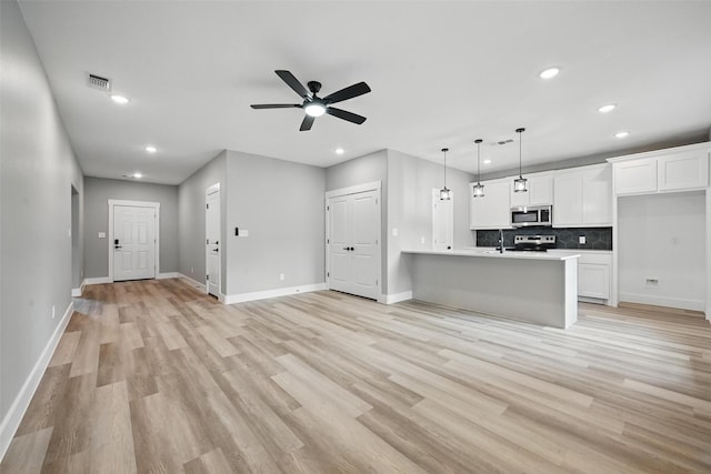 2734 W Washington St, Denison, TX 75020 - unfurnished living room with recessed lighting, a sink, baseboards, ceiling fan, and light wood-style floors