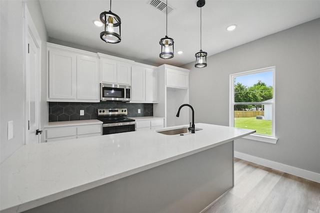 2734 W Washington St, Denison, TX 75020 - kitchen with stainless steel appliances, a sink, tasteful backsplash, white cabinetry, and baseboards