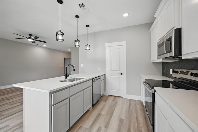 2734 W Washington St, Denison, TX 75020 - kitchen with appliances with stainless steel finishes, a sink, a peninsula, light wood-style floors, and recessed lighting