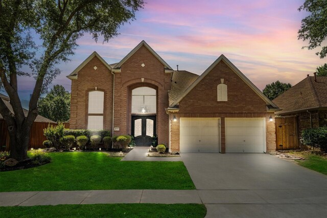 traditional home with french doors, brick siding, and driveway