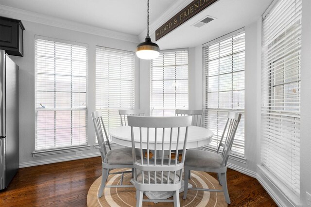 dining space featuring crown molding, dark wood finished floors, and baseboards