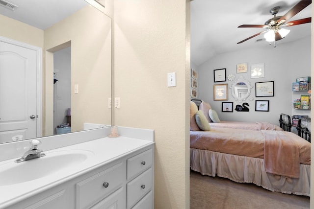 carpeted bedroom with a sink, lofted ceiling, and a ceiling fan