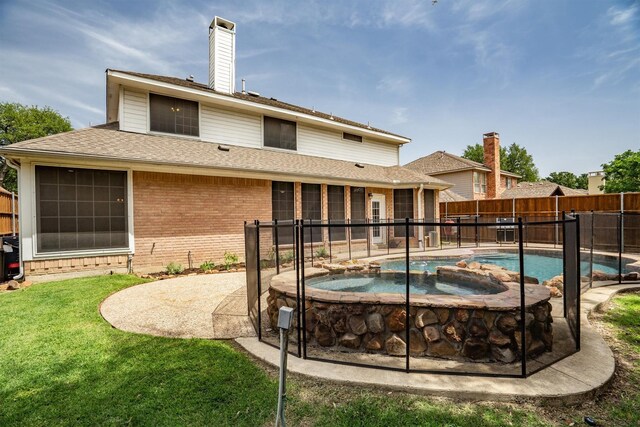 rear view of house featuring brick siding, a chimney, a patio, a pool with connected hot tub, and roof with shingles