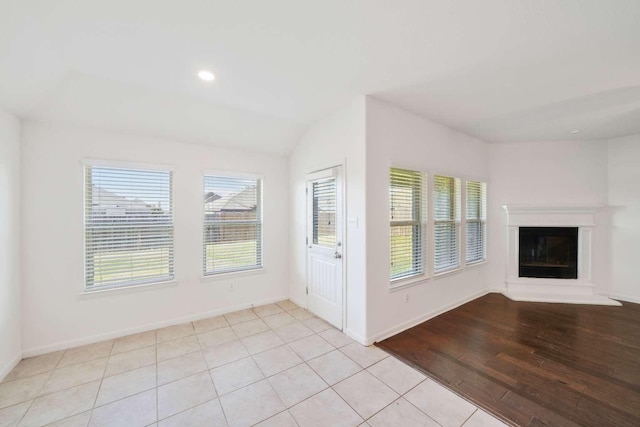 107 Mesa Verde Ct, Forney, TX 75126 - unfurnished living room with plenty of natural light, a glass covered fireplace, baseboards, light tile patterned floors, and recessed lighting