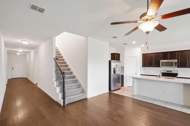 107 Mesa Verde Ct, Forney, TX 75126 - kitchen featuring stainless steel appliances, light countertops, light wood finished floors, a ceiling fan, and dark brown cabinetry