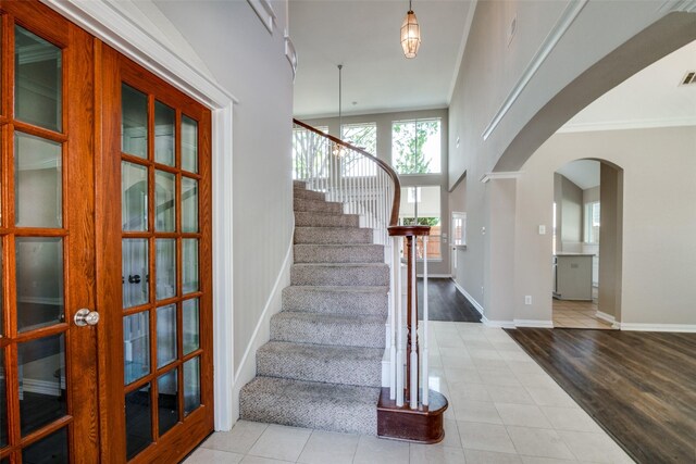 5504 Seneca Dr, Plano, TX 75094 - tiled foyer entrance featuring arched walkways, stairs, baseboards, and ornamental molding