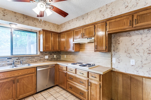 104 NE Rosamond St, Burleson, TX 76028 - kitchen with stainless steel dishwasher, under cabinet range hood, white electric stovetop, a sink, and a ceiling fan