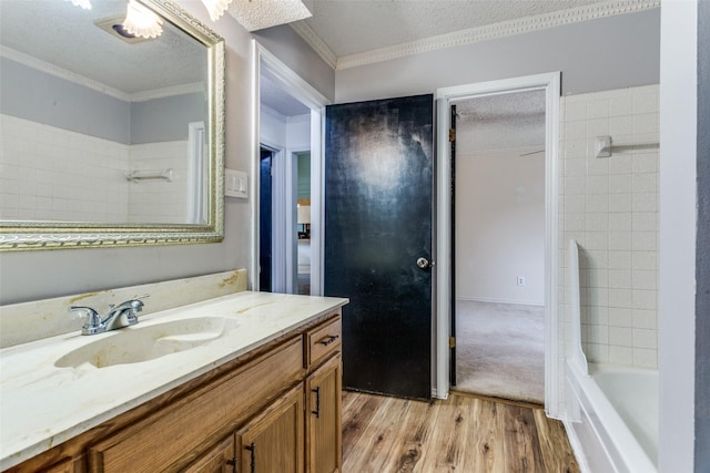 104 NE Rosamond St, Burleson, TX 76028 - full bath with wood finished floors, vanity, crown molding, a textured ceiling, and washtub / shower combination