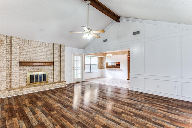 104 NE Rosamond St, Burleson, TX 76028 - unfurnished living room featuring a decorative wall, ceiling fan, wood finished floors, a brick fireplace, and beamed ceiling