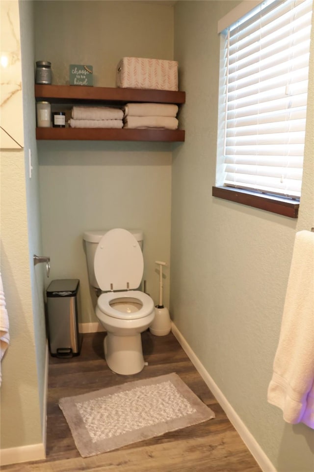 124 Circle Dr, Kaufman, TX 75142 - bathroom with wood finished floors, toilet, and baseboards