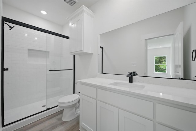912 Layne Dr, Denison, TX 75020 - bathroom with a stall shower, wood finished floors, toilet, vanity, and recessed lighting