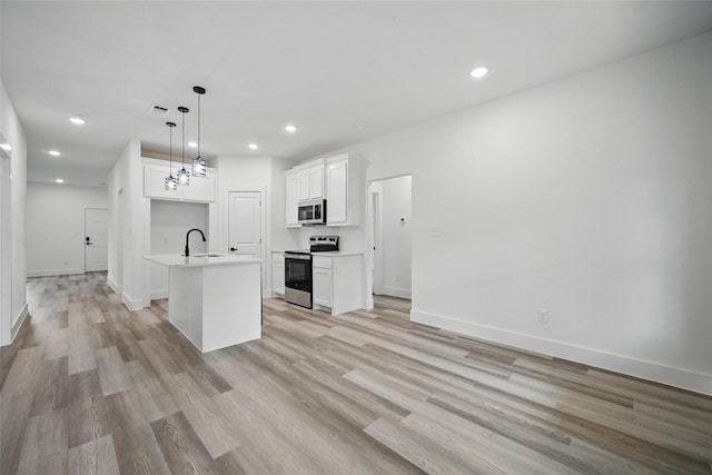 912 Layne Dr, Denison, TX 75020 - kitchen featuring appliances with stainless steel finishes, a sink, light wood-type flooring, white cabinetry, and light countertops