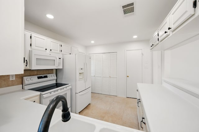 kitchen with white appliances, white cabinetry, light countertops, light tile patterned floors, and recessed lighting