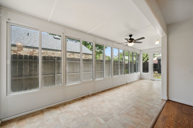 unfurnished sunroom featuring ceiling fan