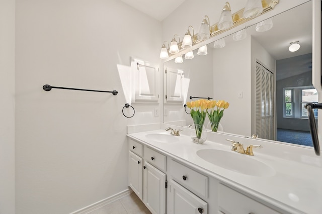 bathroom with double vanity, tile patterned floors, and baseboards