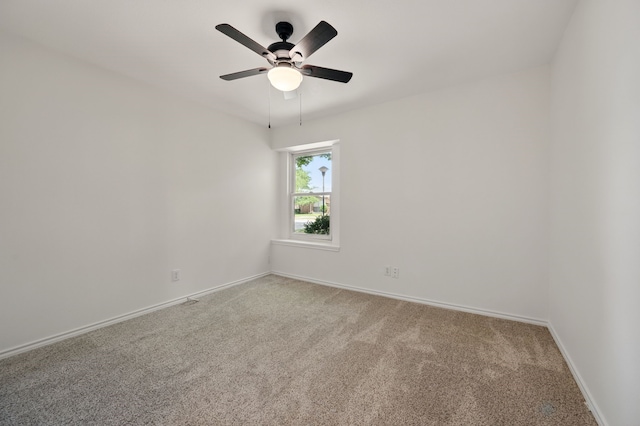 carpeted empty room featuring baseboards and ceiling fan