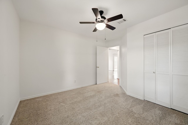 unfurnished bedroom featuring carpet flooring, a closet, baseboards, and a ceiling fan