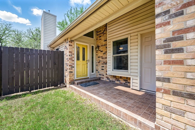 property entrance with fence and a chimney