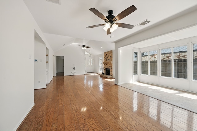 unfurnished living room with a ceiling fan, hardwood / wood-style flooring, vaulted ceiling, baseboards, and a fireplace