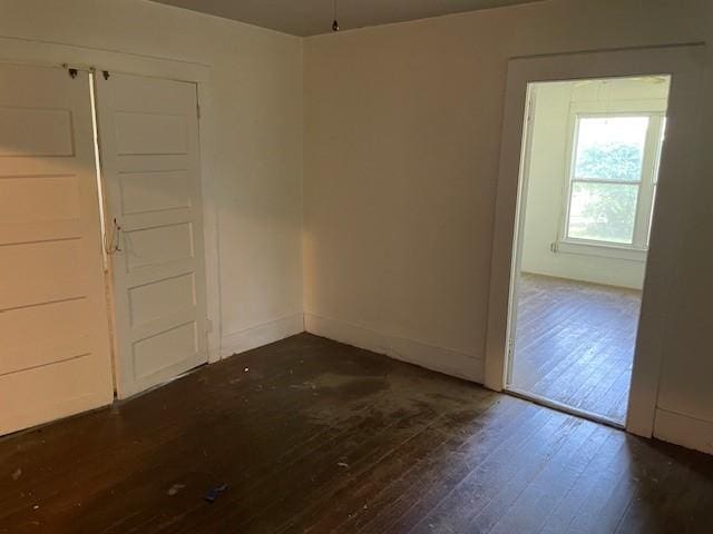 100 E Hill St, Woodson, TX 76491 - empty room with dark wood-style floors and baseboards