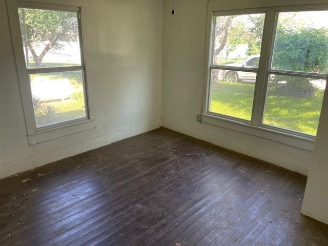 100 E Hill St, Woodson, TX 76491 - unfurnished room with dark wood-type flooring and healthy amount of natural light