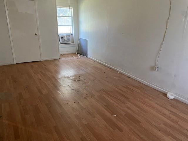 100 E Hill St, Woodson, TX 76491 - unfurnished bedroom featuring wood finished floors, baseboards, and cooling unit
