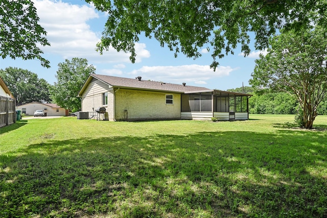 207 Bluebird Cir, Denton, TX 76209 - back of house with a sunroom, brick siding, a yard, and central air condition unit