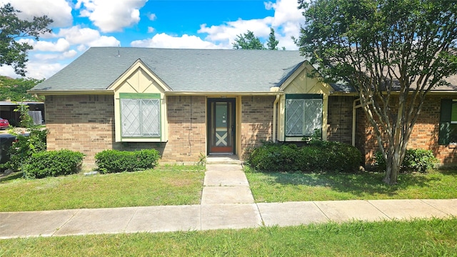 18 E Townhouse Ln Unit 31, Grand Prairie, TX 75052 - view of front of home featuring a front lawn, brick siding, and a shingled roof