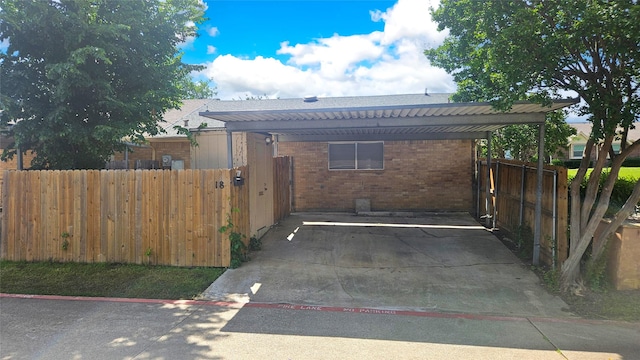 18 E Townhouse Ln Unit 31, Grand Prairie, TX 75052 - view of home's exterior with brick siding, a detached carport, and fence