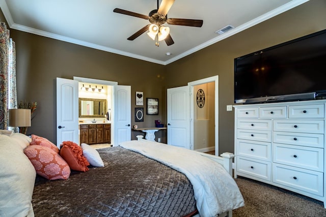 bedroom with dark carpet, crown molding, baseboards, ensuite bath, and ceiling fan